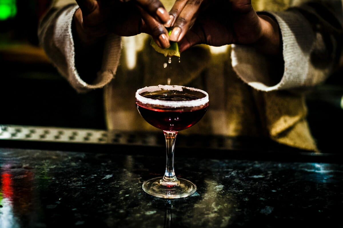person holding clear wine glass with red liquid.jpg