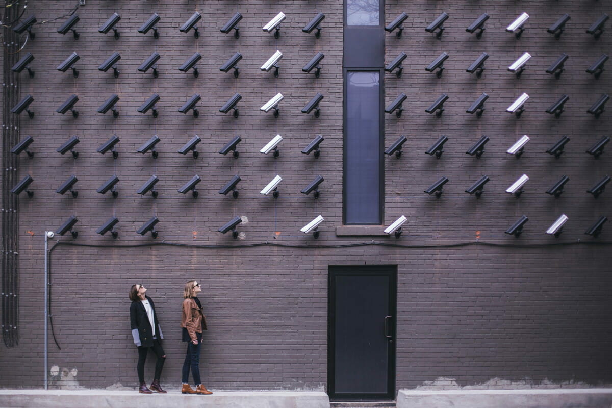 two women facing security camera above mounted on structure.jpg