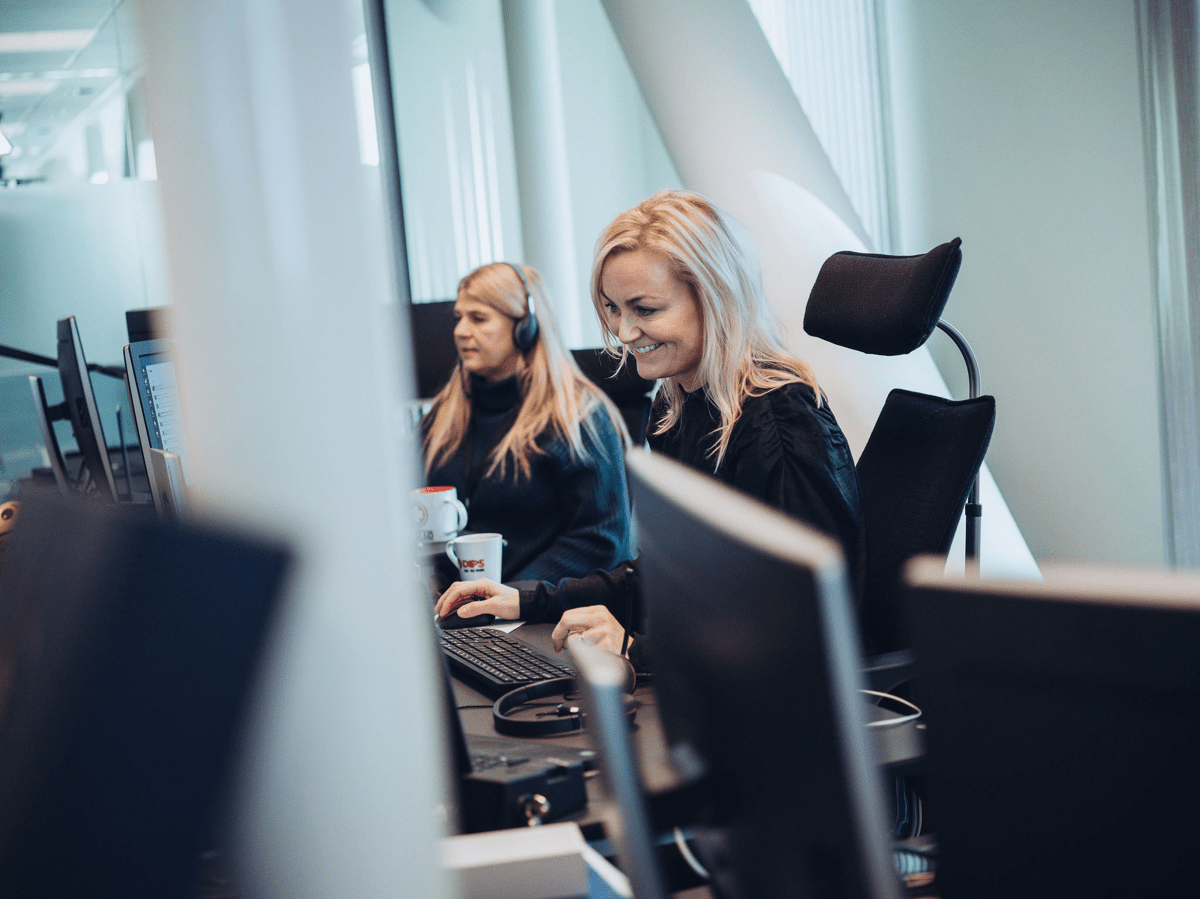 To damer jobber på PC - smilende dame i fokus.jpg