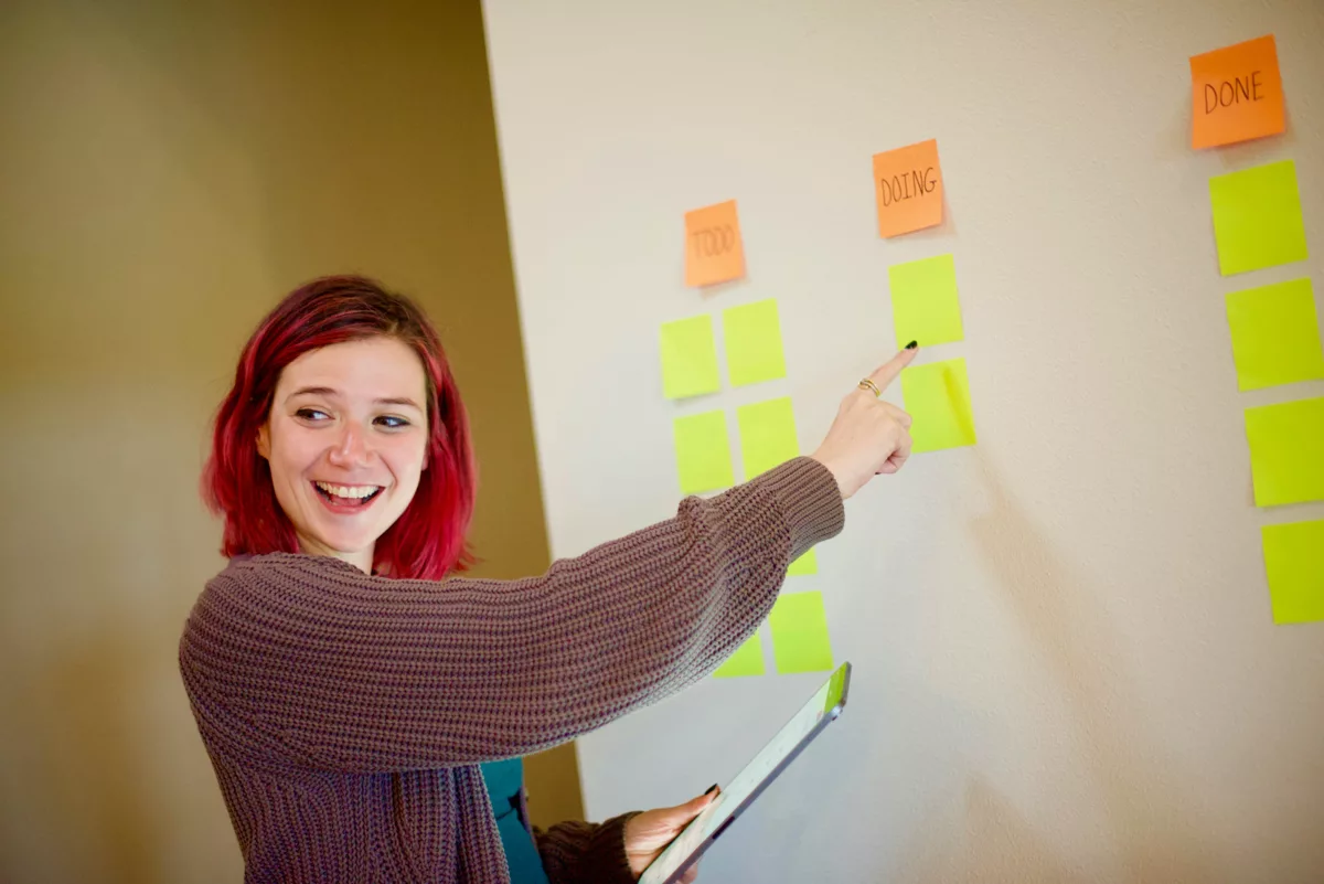 woman in gray sweater holding white and yellow sticky notes.jpg
