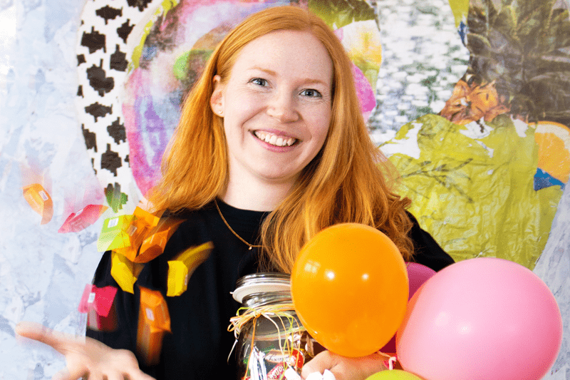 Human Resources Mitarbeiterin hält Luftballons und Süßigkeiten